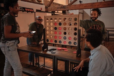 Guests playing a giant Connect Four game inside brwnbox