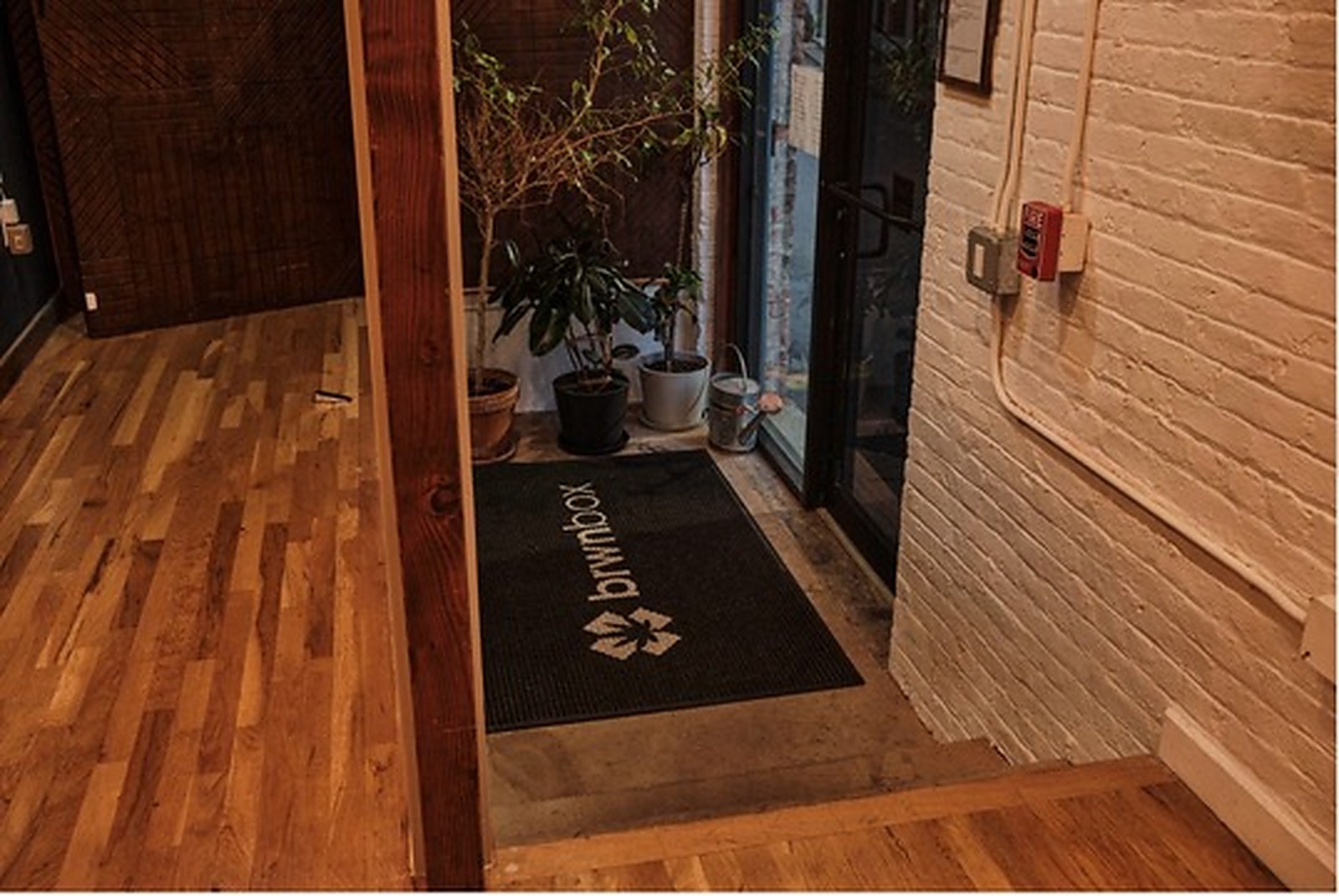 brwnbox entrance with wood flooring and glass doors