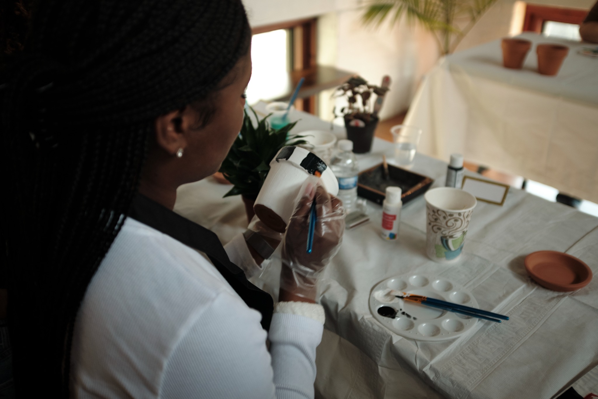 Guest painting pottery during a creative workshop at brwnbox